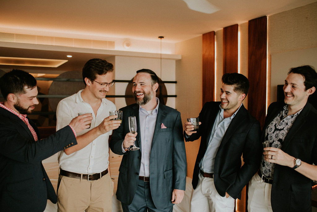 Groom sharing a toast with his groomsmen before his Majestic Elegance Costa Mujeres wedding ceremony.