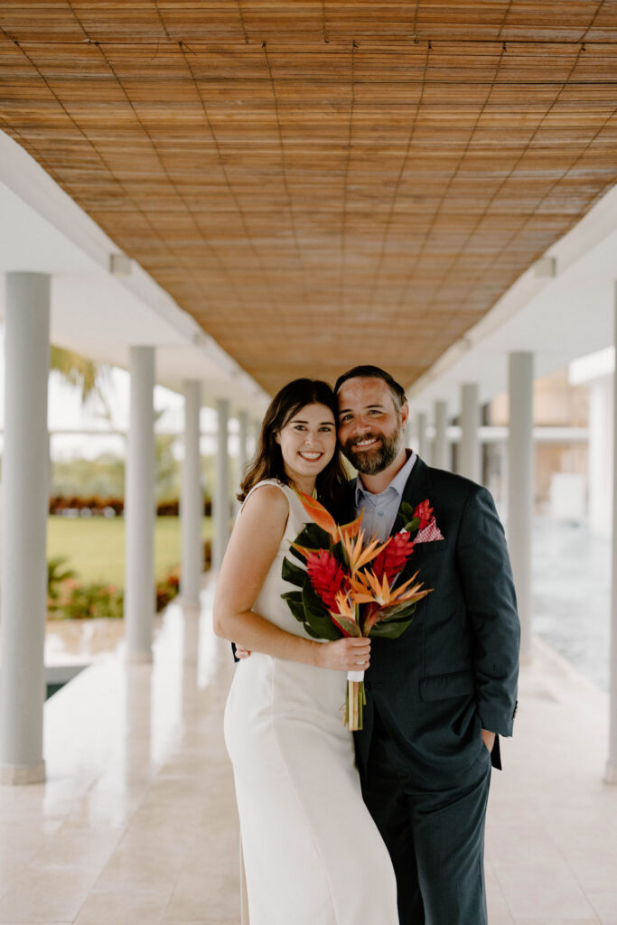 Romantic wedding portrait of newlyweds beneath a covered walkway at Majestic Elegance Costa Mujeres.