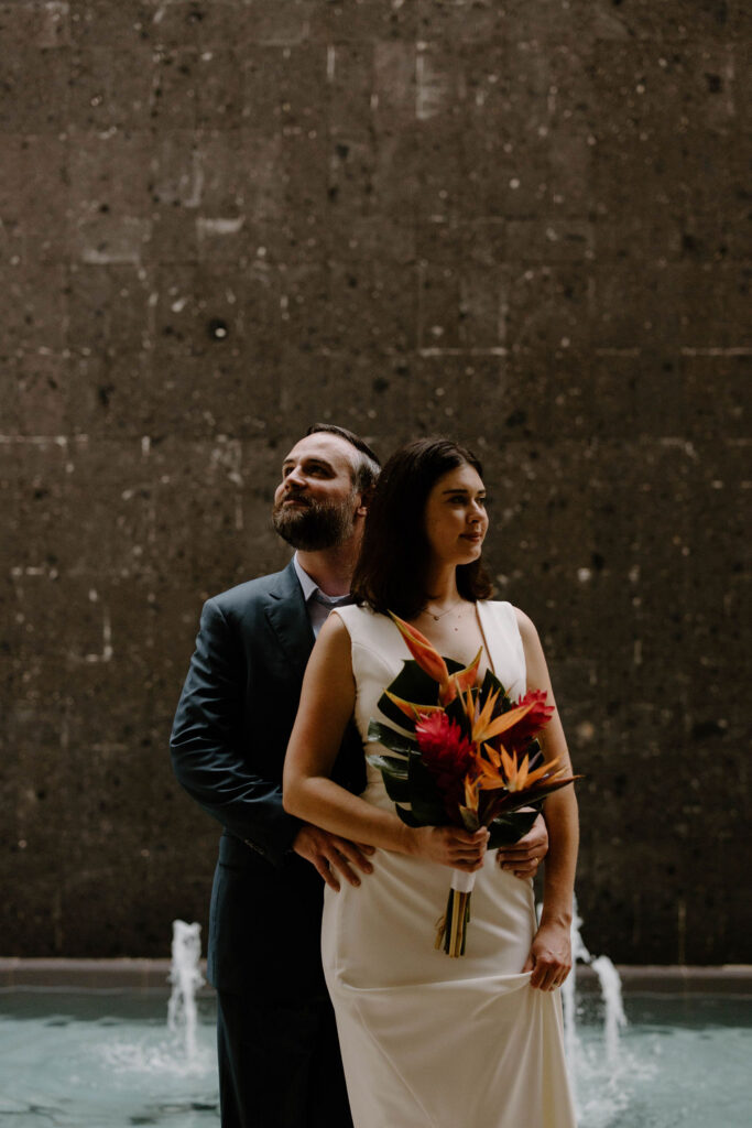 Elegant destination wedding portrait featuring tropical bridal bouquet and resort architecture in Costa Mujeres Mexico