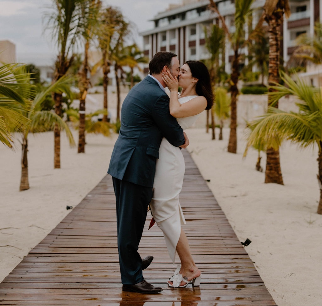 Romantic beachside wedding portrait of newlyweds on the beach boardwalk at Majestic Elegance Costa Mujeres.