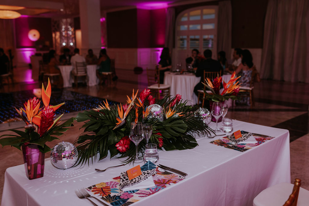 Custom tropical wedding reception decor and tablescape at Majestic Elegance Costa Mujeres.