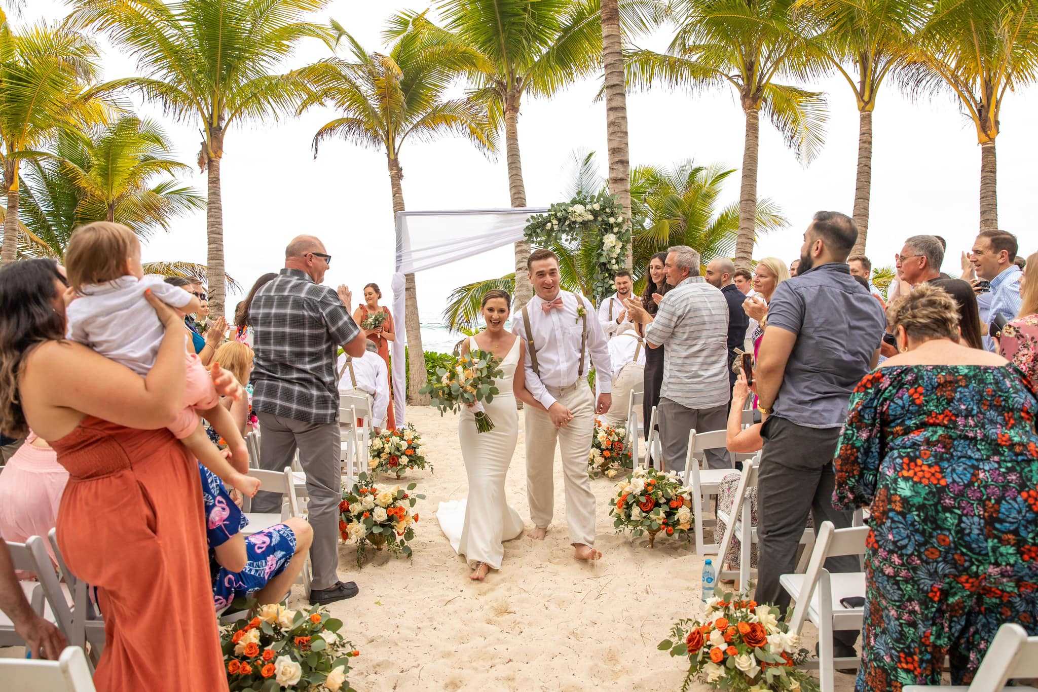 Bride and groom walking down the aisle after their Fuentes Beach ceremony at El Dorado Casitas Royale