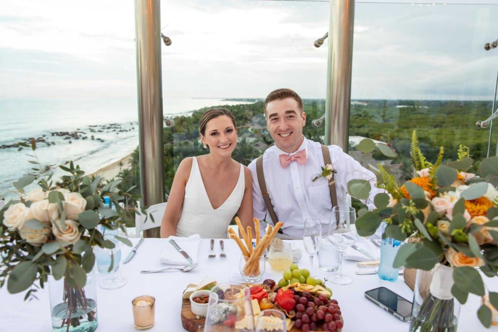 Newlyweds seated at their Sky Deck reception overlooking Riviera Maya