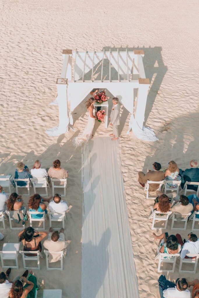 Drone photo of a couple exchanging vows during a beach wedding ceremony at Secrets Maroma Beach Riviera Cancun.