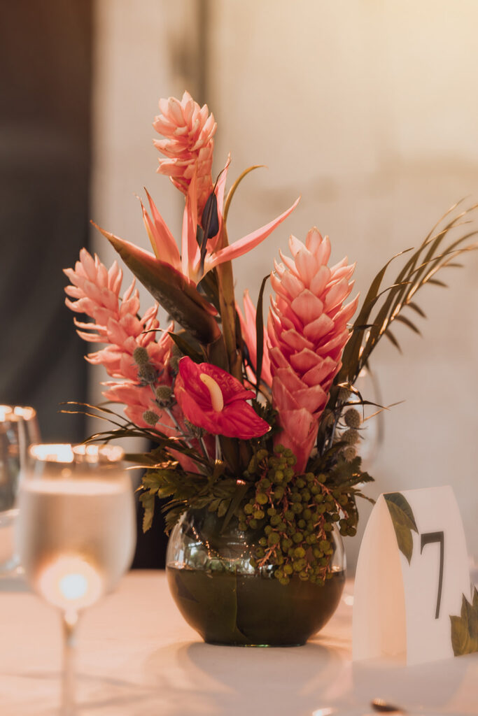 Tropical floral centerpiece decorating a wedding reception table at Secrets Maroma Beach Riviera Cancun.