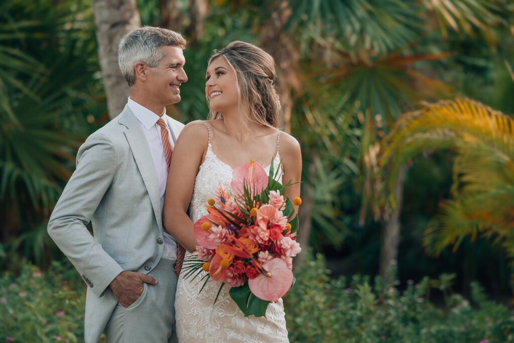Romantic portrait of a bride and groom by the palm trees at Secrets Maroma Beach Riviera Cancun.