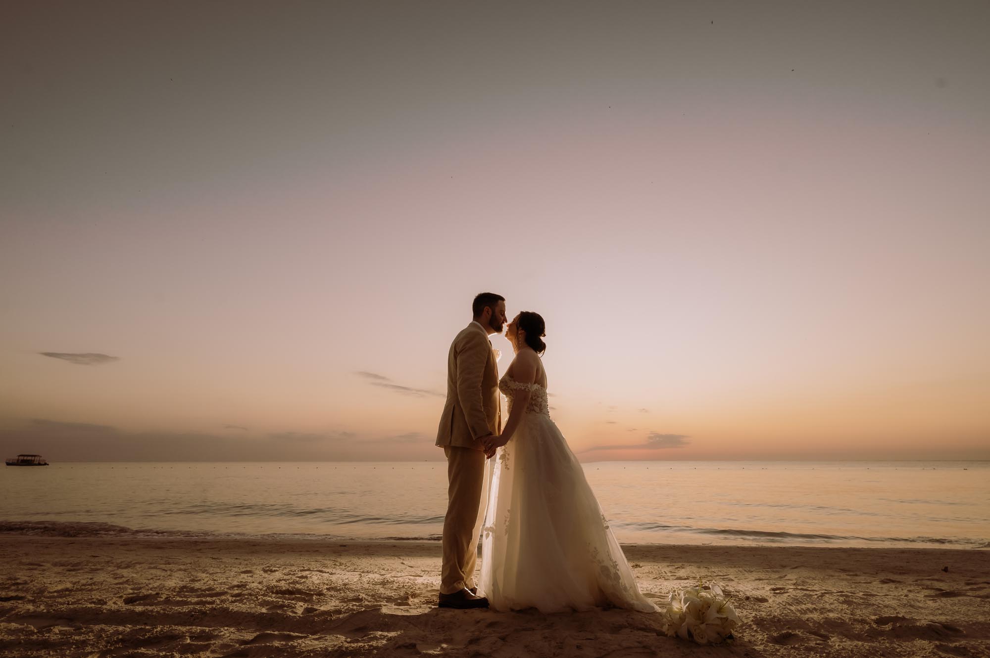 Couple kissing during sunset and feeling relaxed after using a travel agent for destination wedding