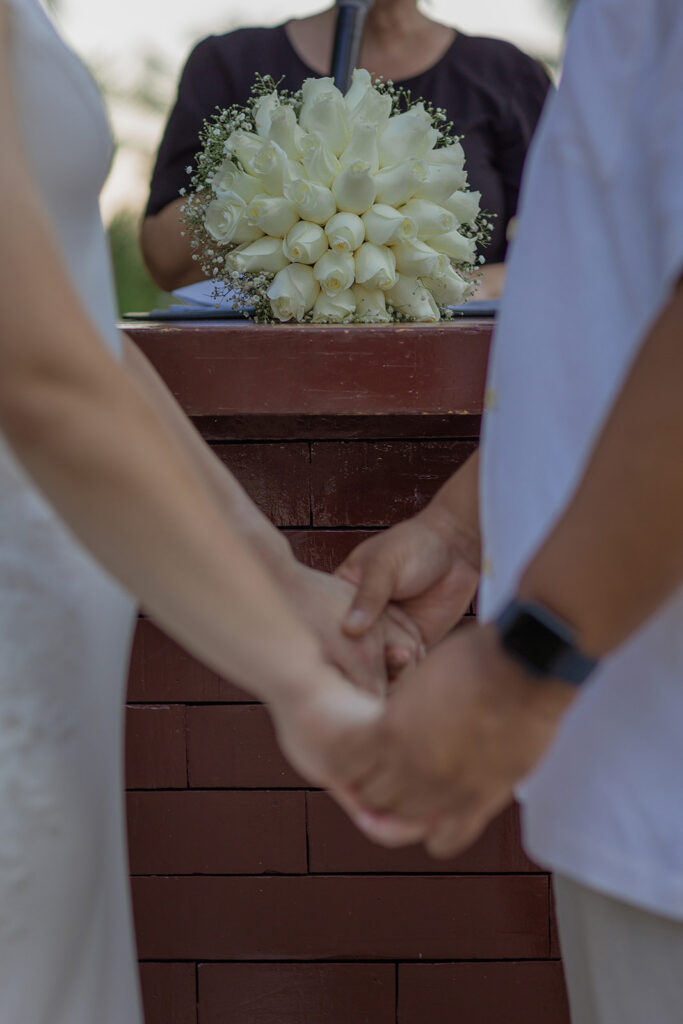 Bride and groom holding hands during their intimate wedding ceremony at Unico 2087