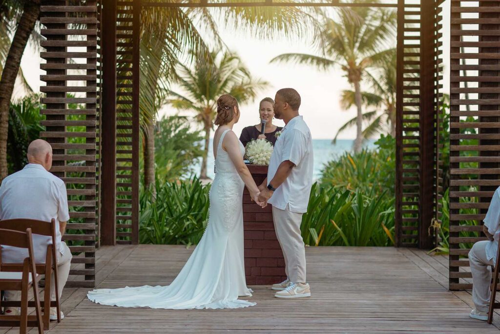 Bride and groom exchanging vows during an intimate Riviera Maya destination wedding ceremony at UNICO 20°87° surrounded by tropical gardens and ocean views