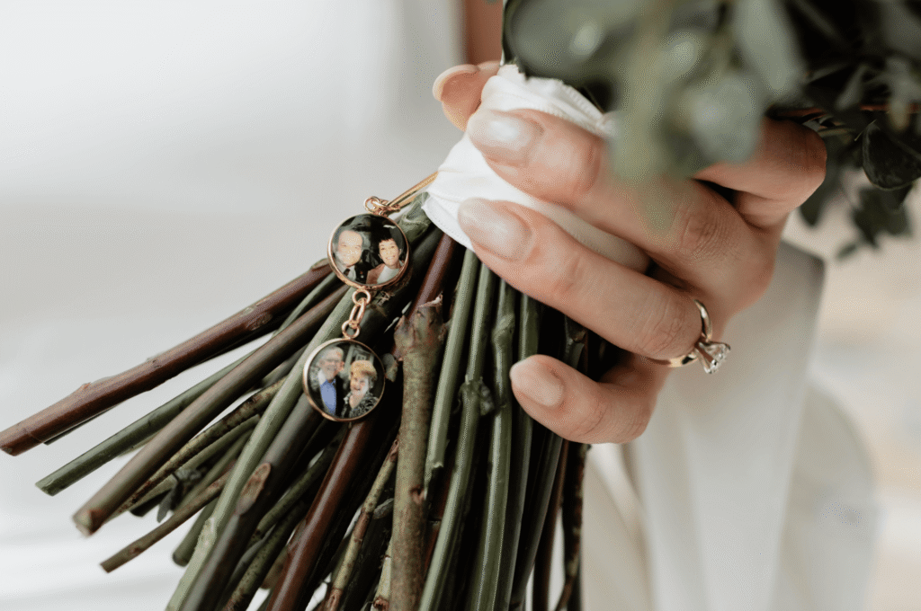 Bride holding her bouquet with a memorial photo charm honoring loved ones during a destination wedding ceremony.