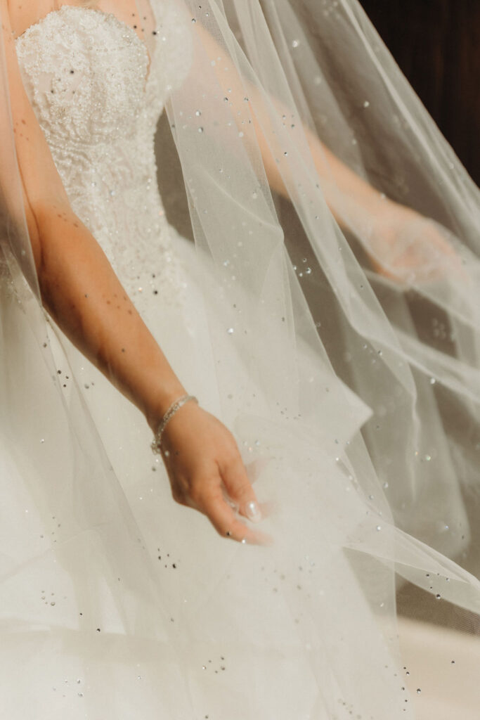 Close-up of a sparkling bridal gown and veil during destination wedding preparations.