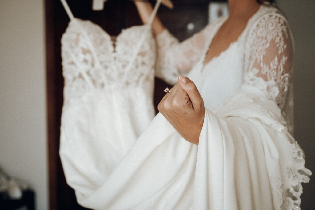 Bride holding her wedding dress during destination wedding preparations before the ceremony.