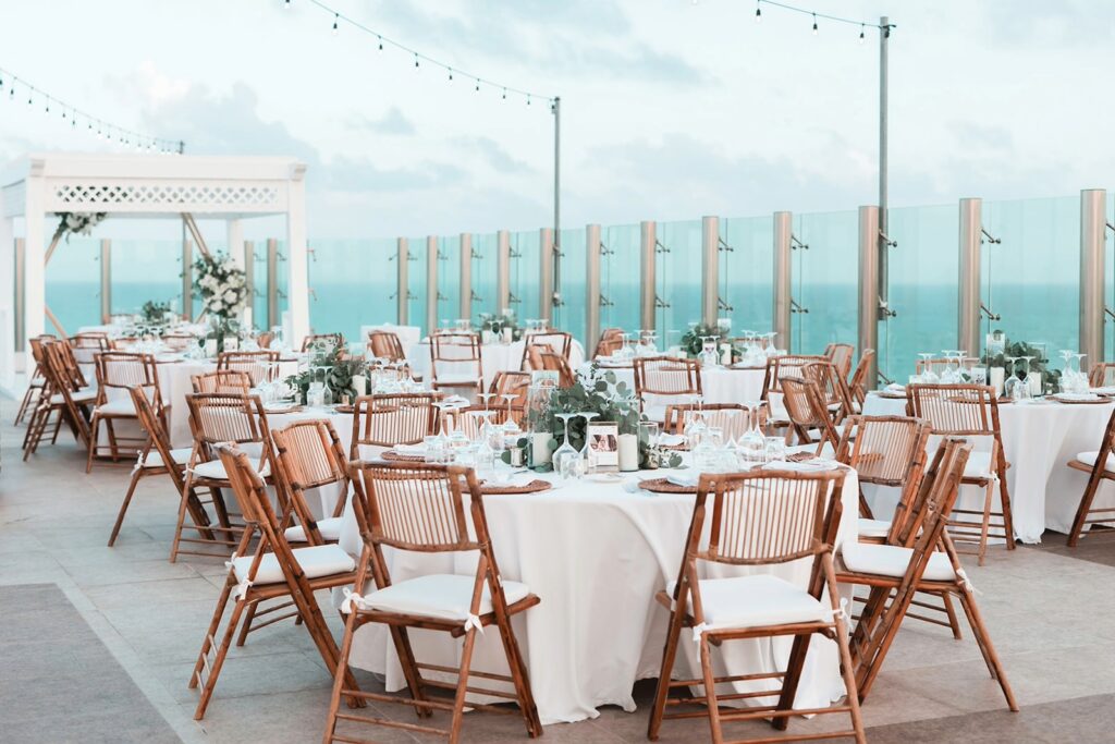 Oceanview reception venue with white linens and rattan chairs at a destination wedding location in Mexico